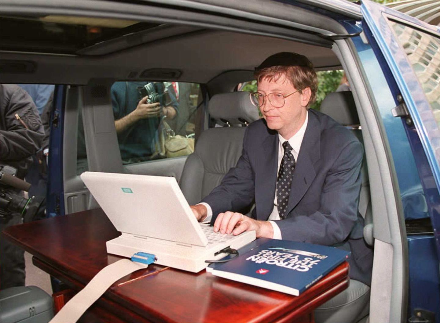 Microsoft president Bill Gates demonstrates Microsoft's Windows 95 program from his automobile prior to a press conference in Paris in September 4, 1995.