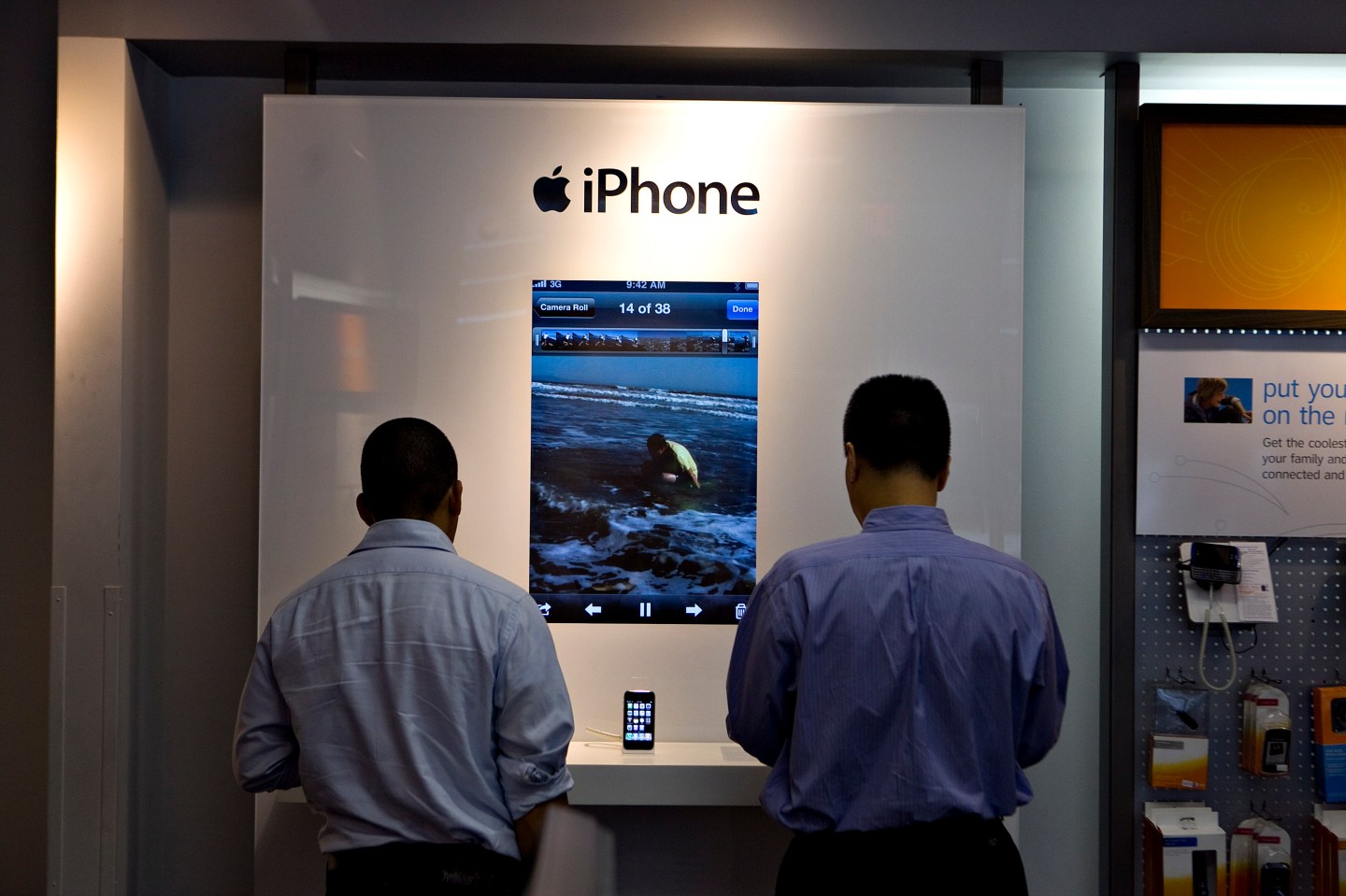 Customers look over iPhone handsets inside an AT&T store in New York, U.S.
