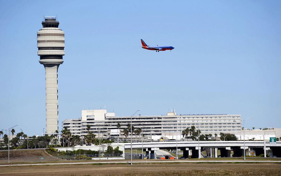 Airplane Jet prepares to land Control Tower at Orlando International Airport Florida