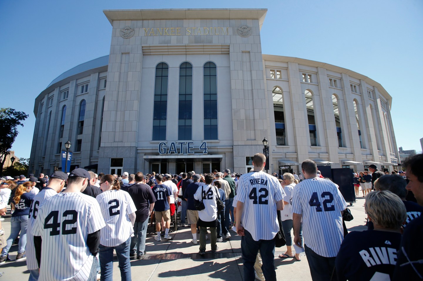 Fans wearing the number 42 of New York Yankees relief pitcher Mariano Rivera line up to enter the stadium in MLB game in New York