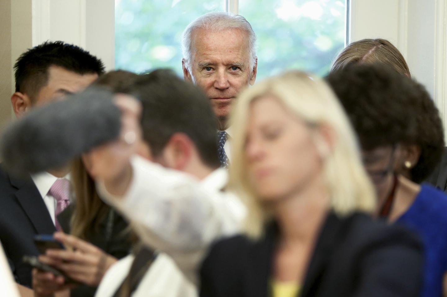 U.S. Vice President Biden stands behind reporters as President Obama and U.N. Secretary-General Ban make statements after their meeting in the Oval Office at the White House in Washington