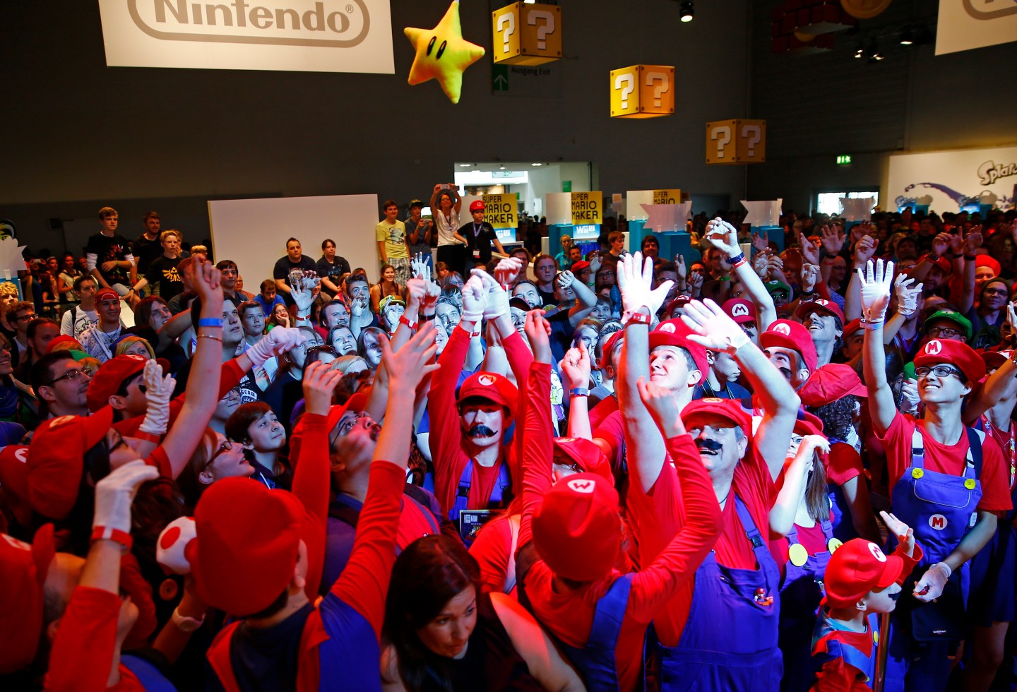 Cosplayers dressed as character "Mario" celebrate the 30th anniversary of "Super Mario Bros." video games developed by Nintendo during the Gamescom 2015 fair in Cologne