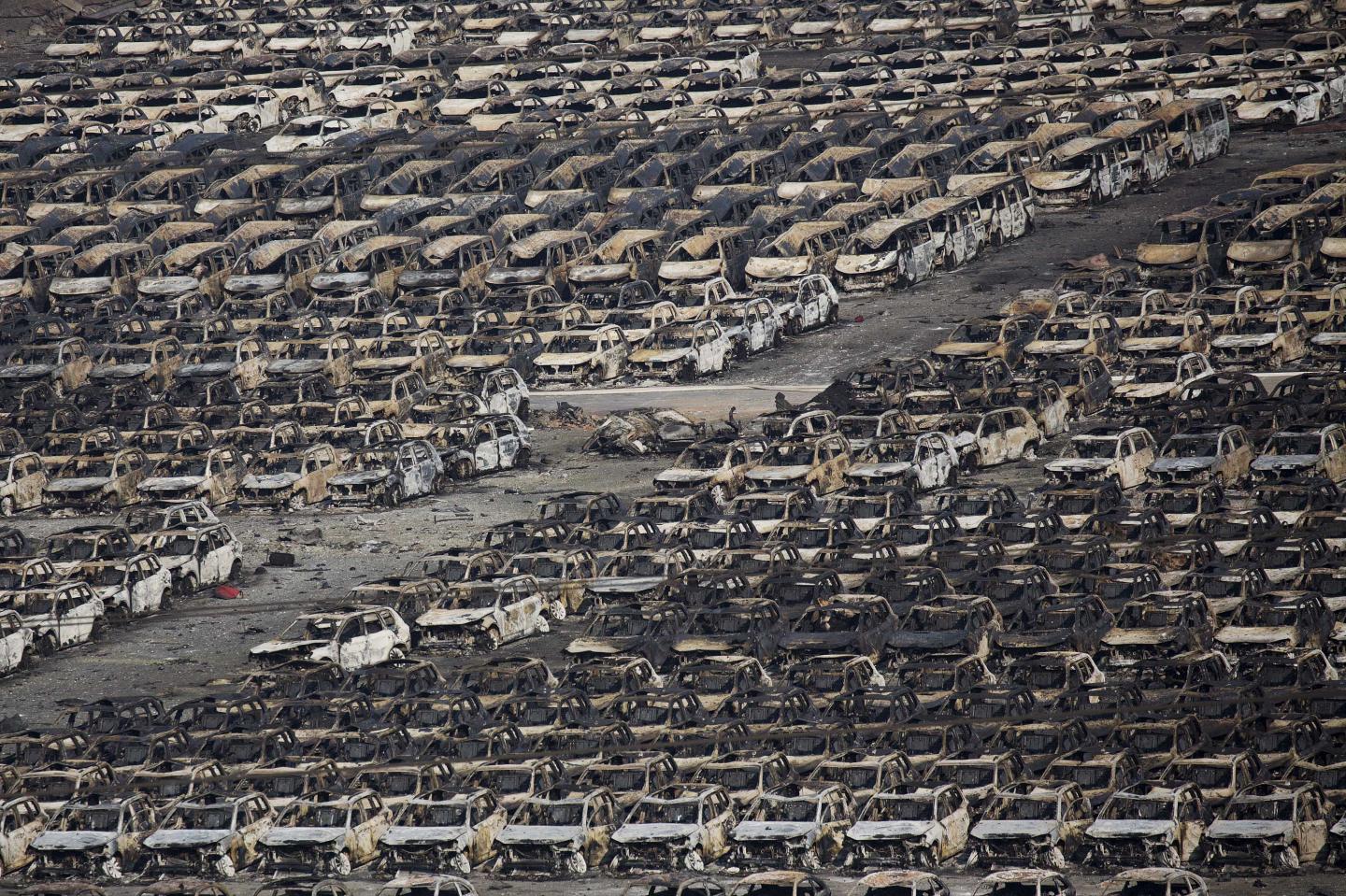 Burnt cars are seen near the site of the explosions at the Binhai new district, Tianjin