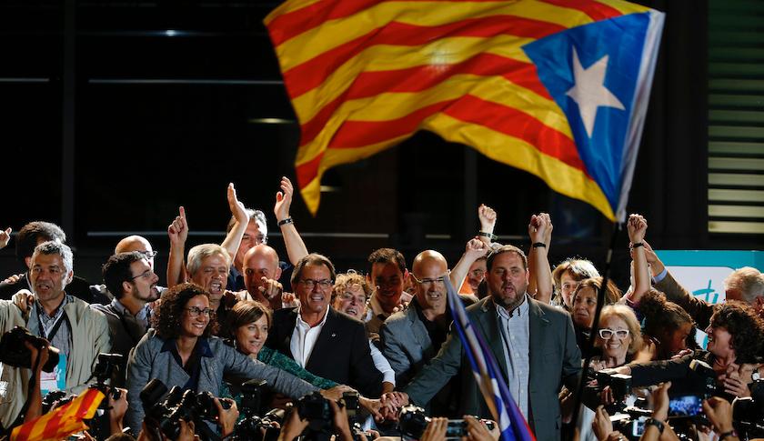 Catalan President Artur Mas (center left, glasses) joins hands with candidates for Junts pel Si after polls closed in Barcelona Sunday night.