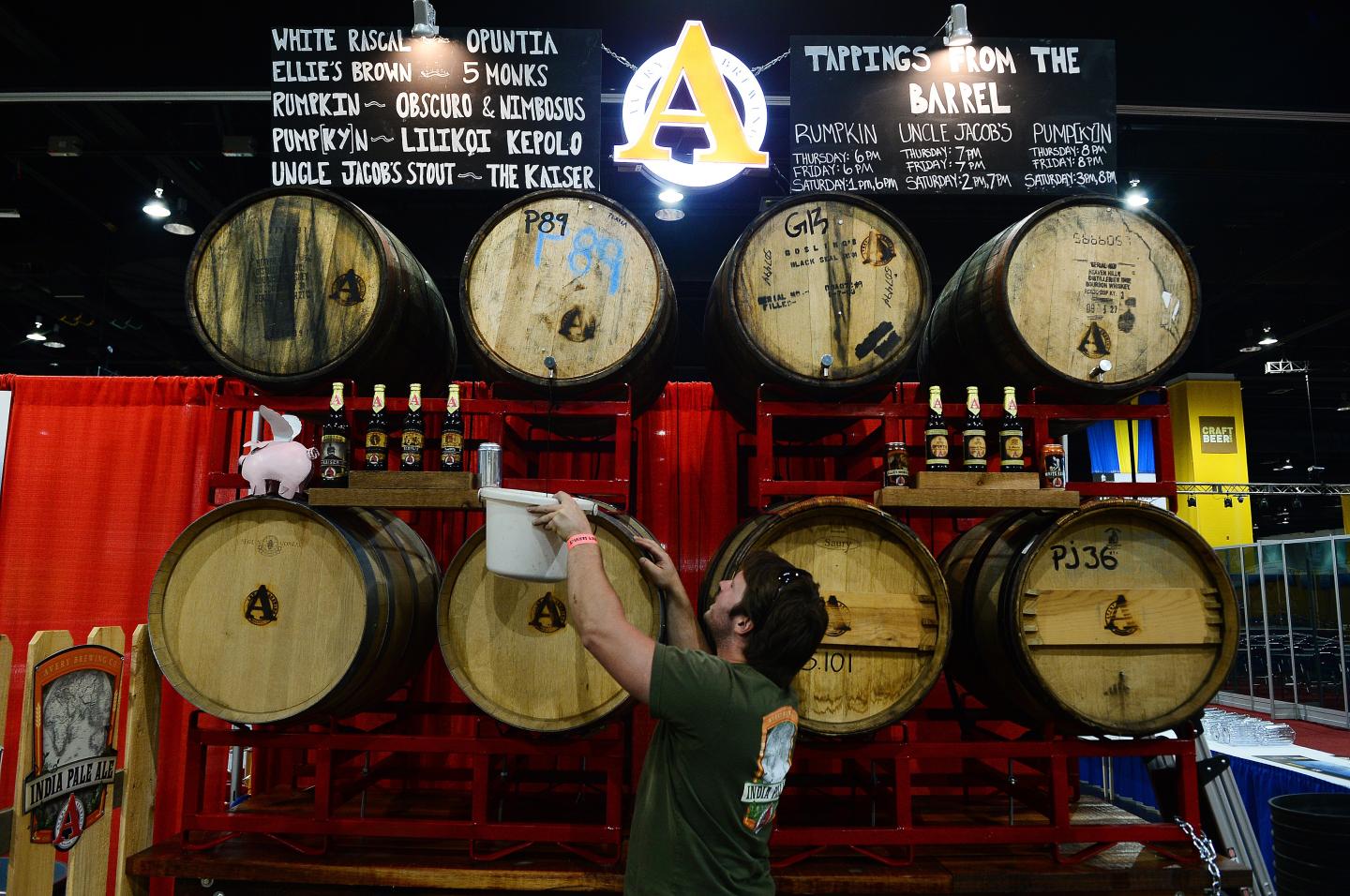 An employee of Avery Brewing Company taps into a barrel as he and his team set up for last year's Great American Beer Festival in Denver.