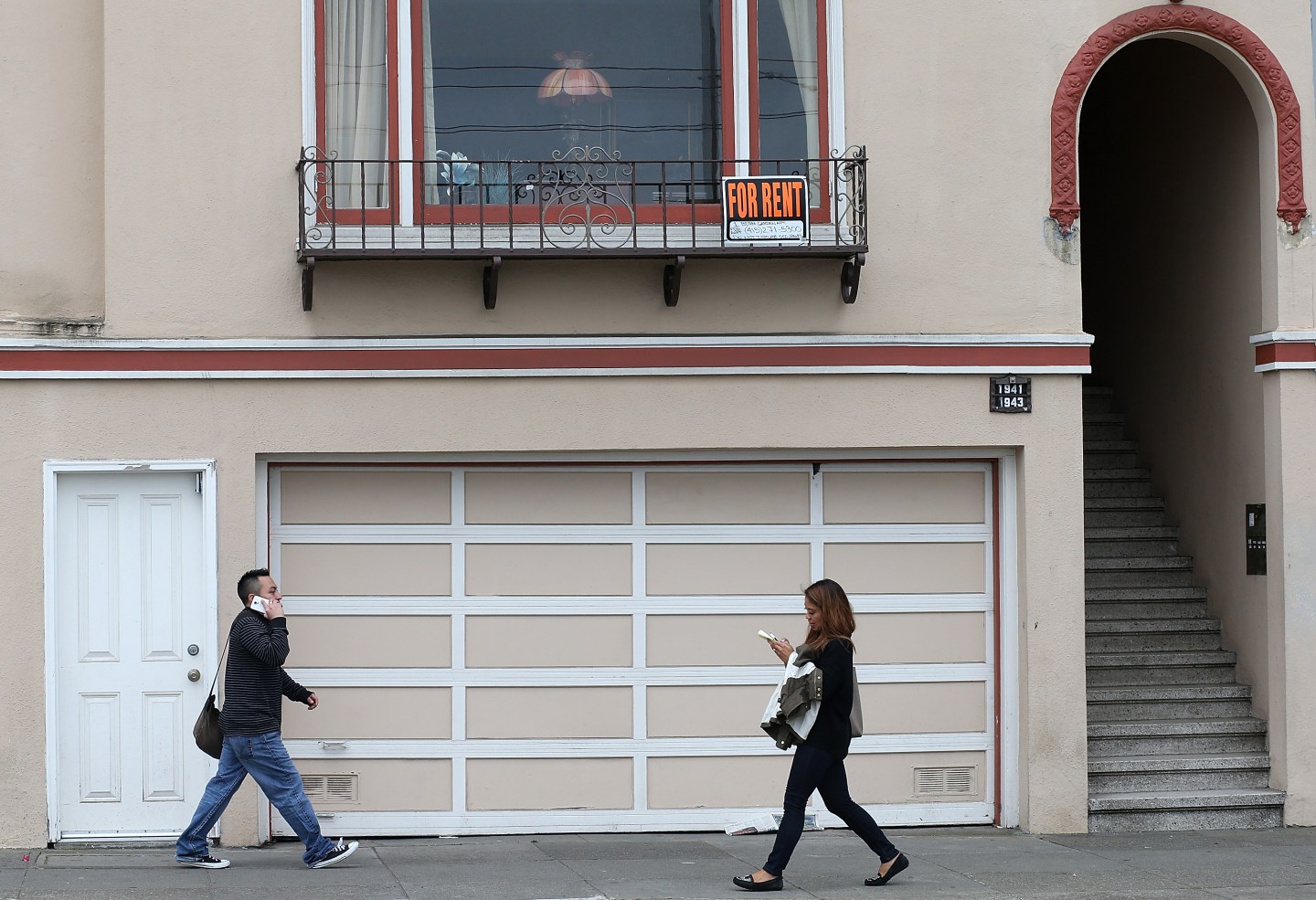 Pedestrians walk by an apartment for rent in San Francisco, California.