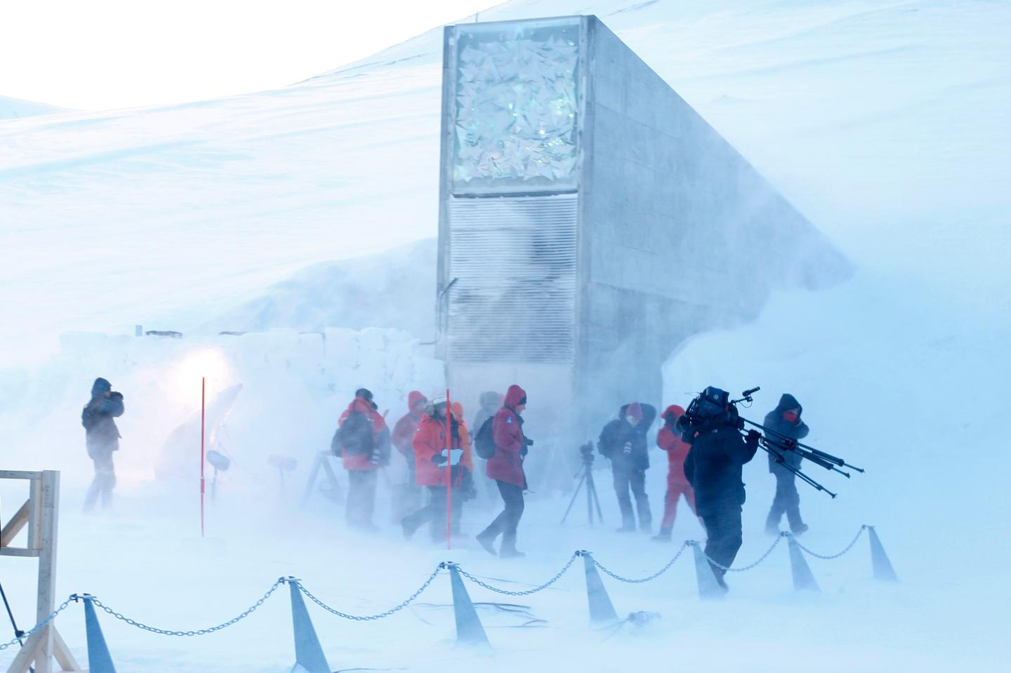 Journalists and cameramen walk under a g
