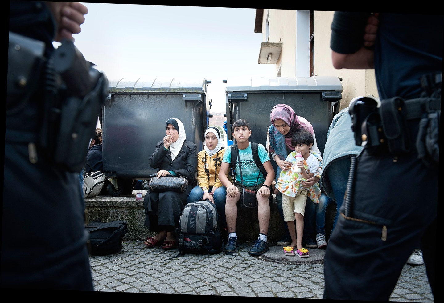 Recently arrived migrants at a train station wait to be put on buses in Passau.