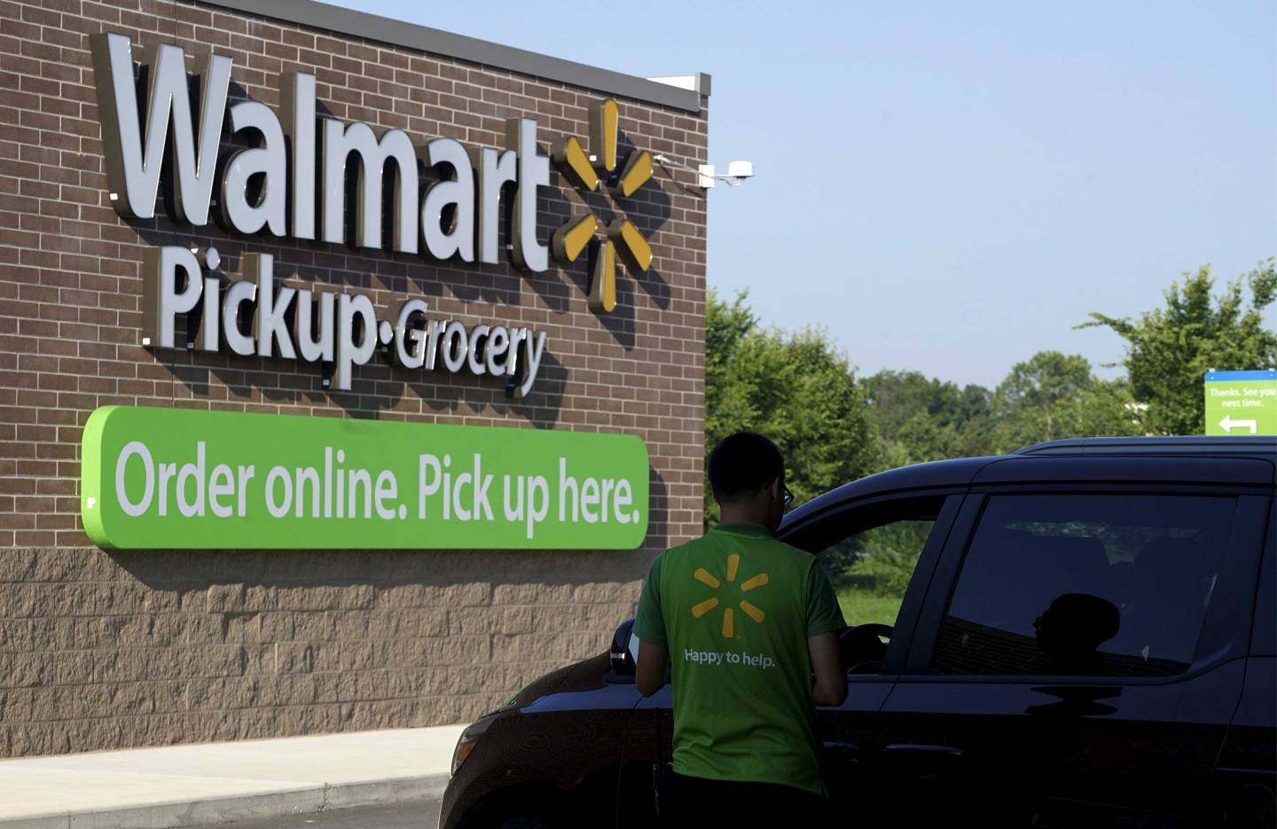 A Wal-Mart Pickup-Grocery employee helps a customer at a test store in Bentonville