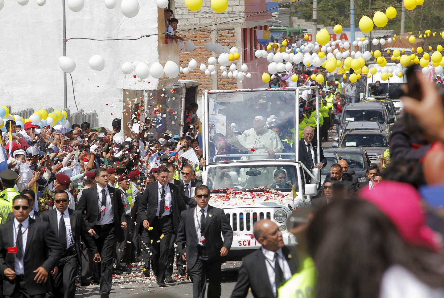 Pope Francis waves to the faithful from a popemobile in El Quinche