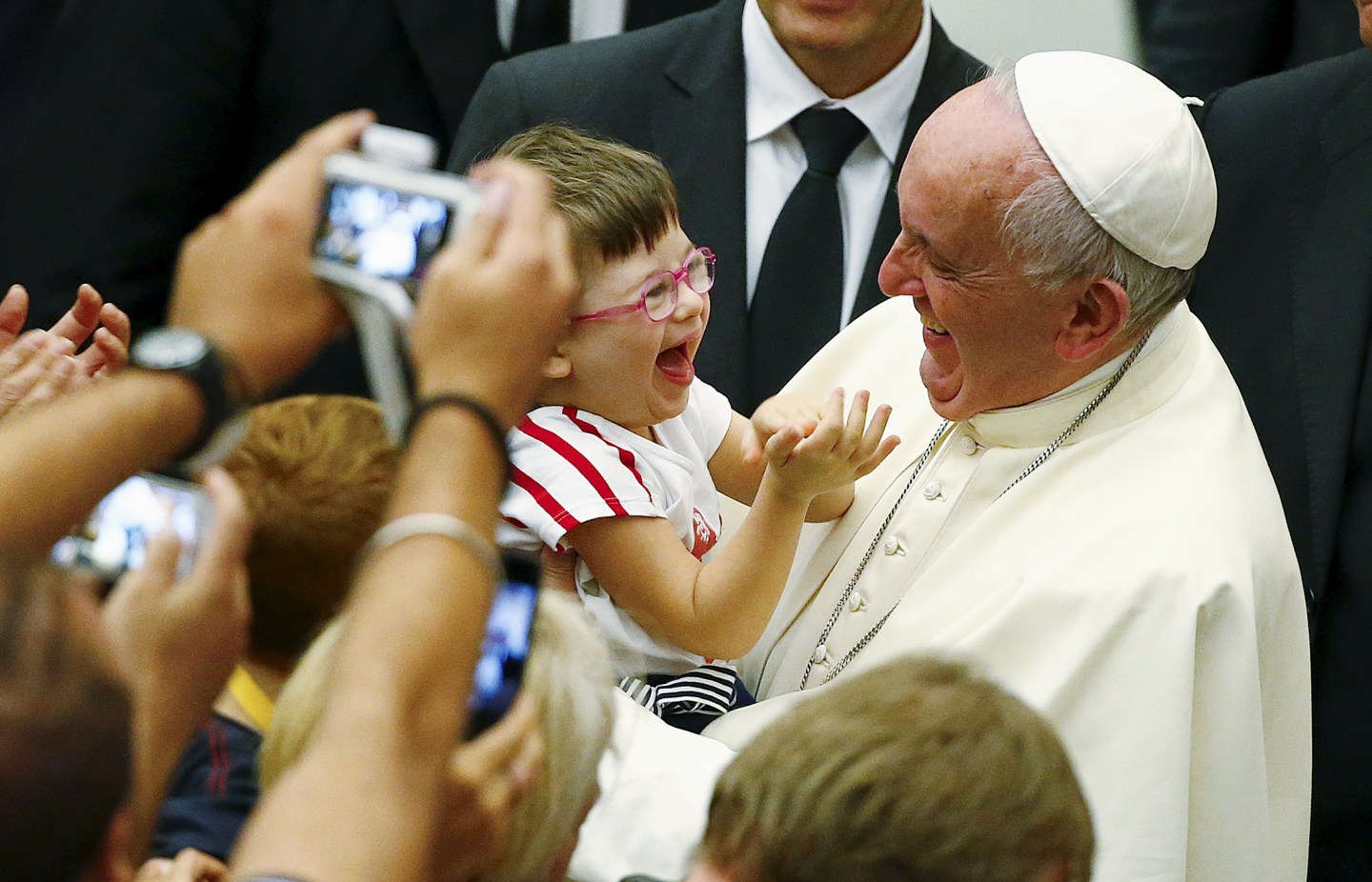 Pope Francis laughs with a baby during a special audience with parish cells for the evangelization in Paul VI hall at the Vatican