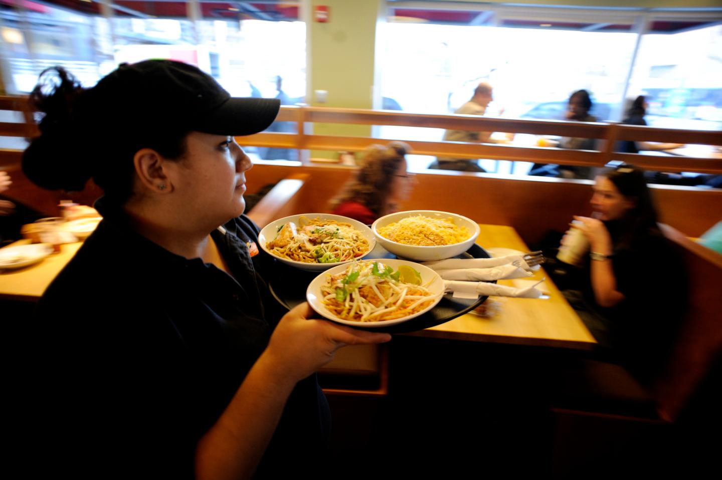 Debbie Teran carries a platter of food to patrons on Monday, December 27, 2010 at Noodles and Company in downtown Denver. Location general manager Ryan Quinn said the restaurant serves between 400-500 customers during the weekday lunch rush. "(Our) lunch