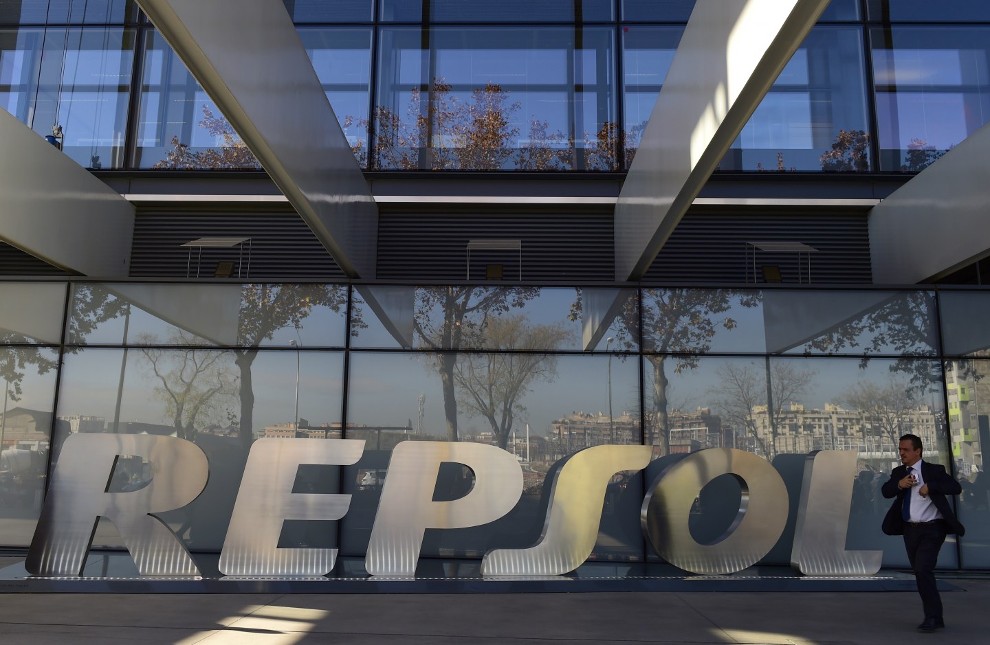 A man walks past the headquarters of Spanish oil company Repsol in Madrid.