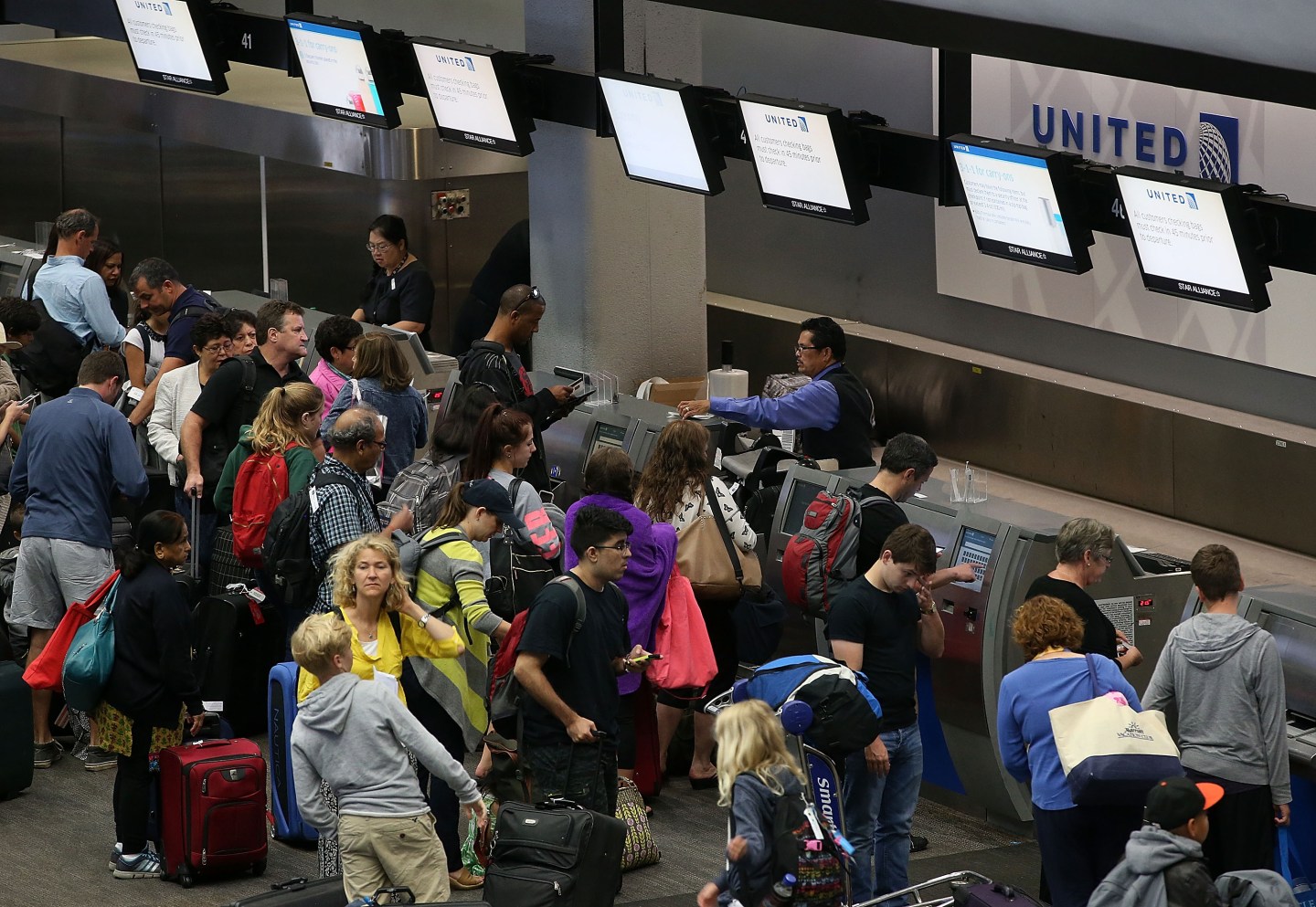 United Airlines passengers wait in line to check in for flights at San Francisco International Airport on July 8, 2015 in San Francisco, California.