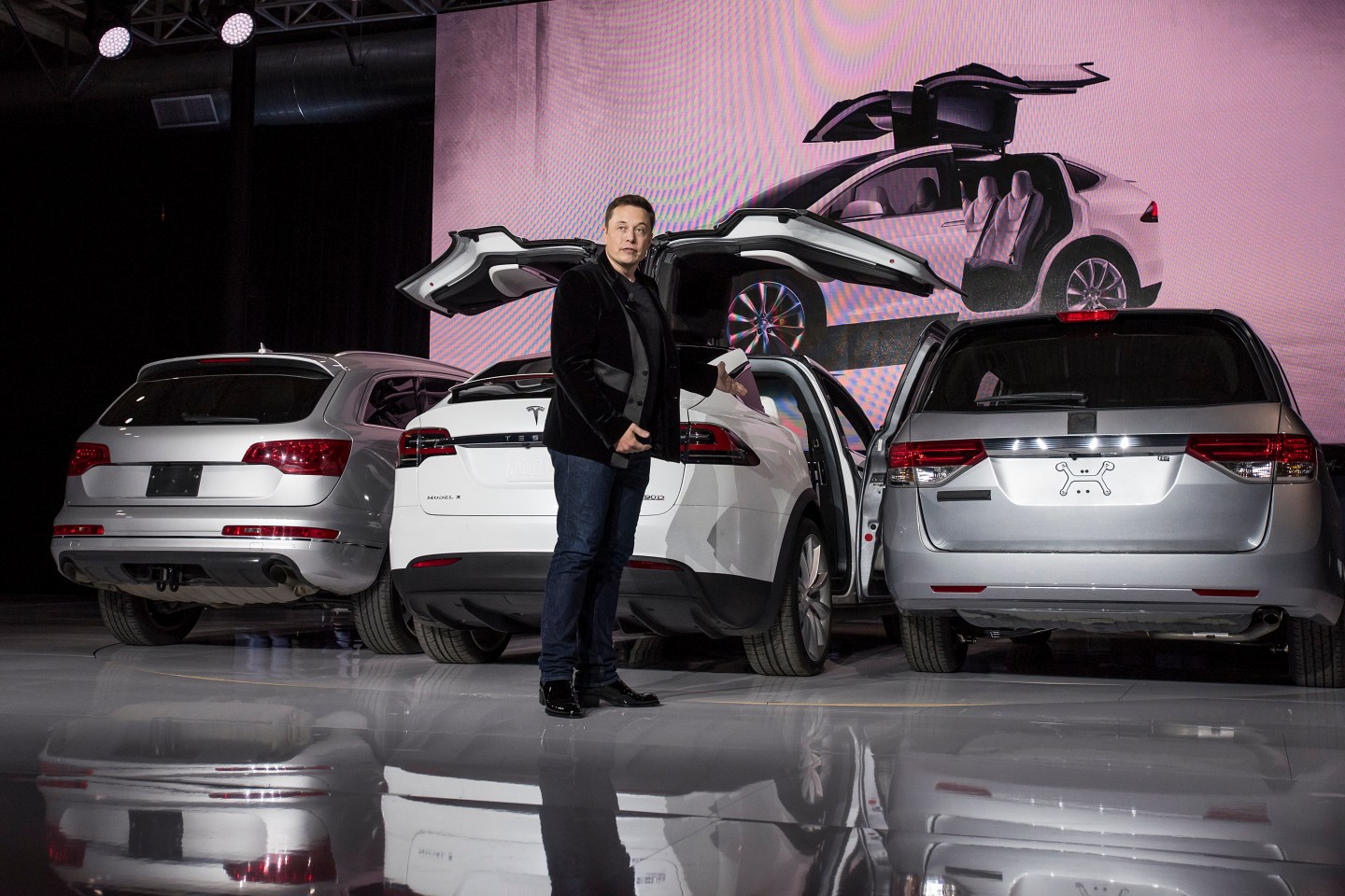 Elon Musk, chairman and chief executive officer of Tesla Motors Inc., demonstrates the falcon doors unveils the Model X sports utility vehicle (SUV) during an event in Fremont, California, U.S., on Tuesday, Sept. 29, 2015. Tesla Motors Inc., the smallest publicly held U.S. automaker, hands over the first of its Model X sport utility vehicles Tuesday evening amid growing scrutiny of Volkswagen AG, one of the world's biggest car companies, after the admission that it cheated on emissions tests. Photographer: David Paul Morris/Bloomberg *** Local Caption *** Elon Musk