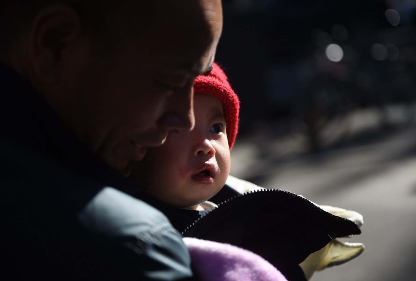 A young boy is held by his grandfather on a path in Beijing on October 30, 2015.