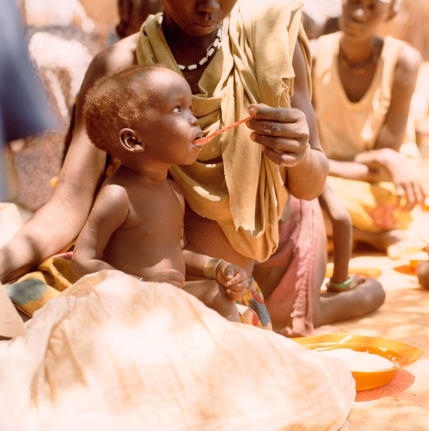 A Dinka child feeds in Sudan, Africa.