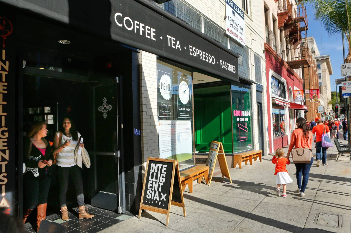 People leave Intelligentsia Coffee House as pedestrians walk along the sidewalk on Colorado Blvd.in