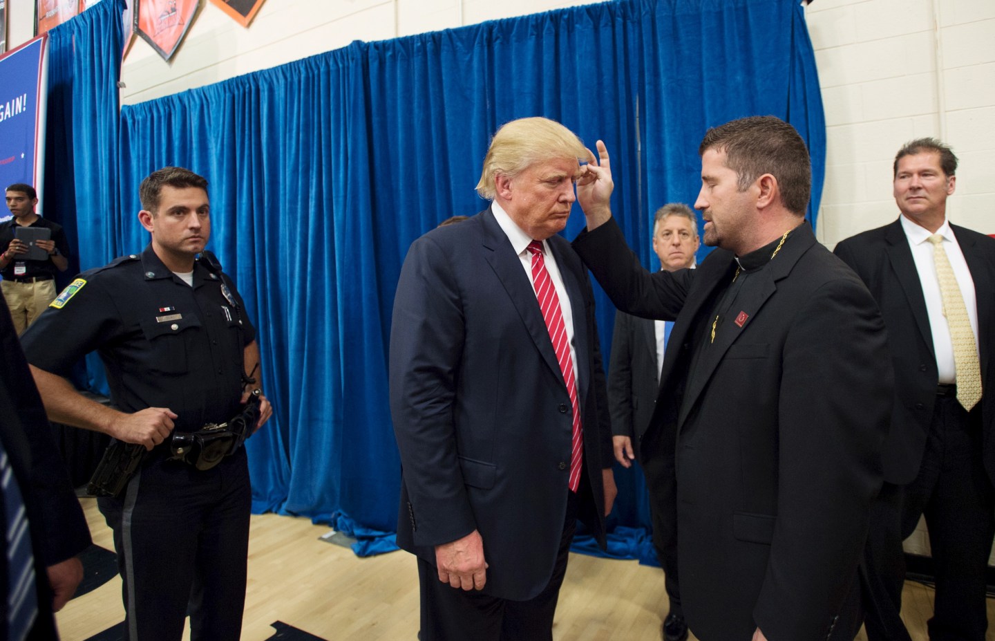 U.S. Republican presidential candidate Donald Trump is blessed by Father Emmanuel Lemelson after speaking at a campaign rally in Keene