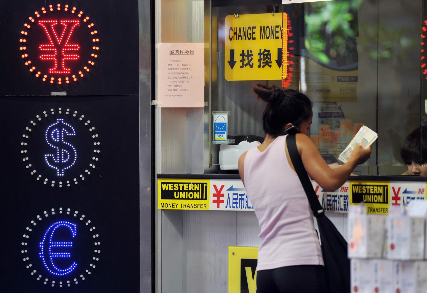 A woman exchanges money at a currency exchange shop in Hong Kong.