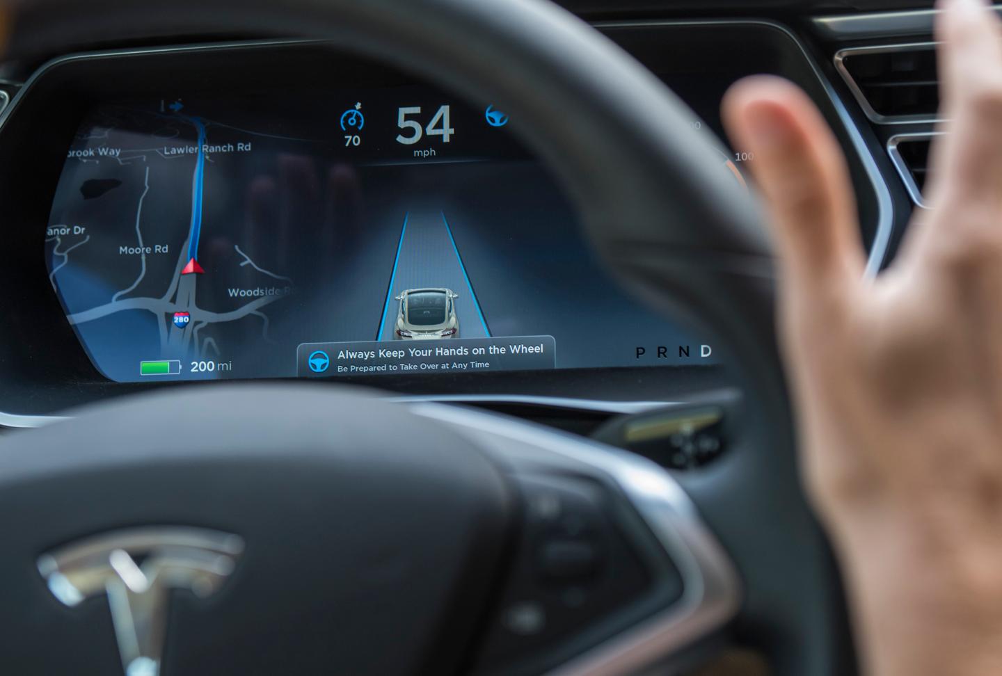 A member of the media test drives a Tesla Motors Inc., Model S car equipped with Autopilot at the Tesla Motors Inc. headquarters in Palo Alto, California, U.S., on Wednesday, Oct. 14, 2015. Tesla Motors Inc. will begin rolling out the first version of its highly anticipated “autopilot” features to owners of its all-electric Model S sedan Thursday. Autopilot is a step toward the vision of autonomous or self-driving cars, and includes features like automatic lane changing and the ability of the Model S to parallel park for you. Photographer: David Paul Morris/Bloomberg