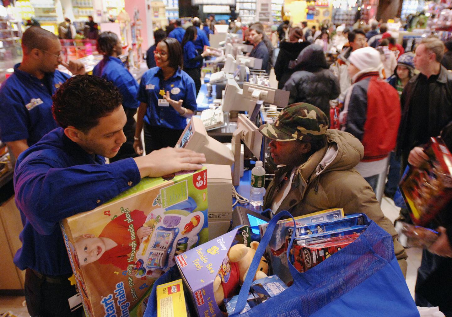 A parent buys Christmas gifts for her three children at a Toys R Us store in New York's Times Square.