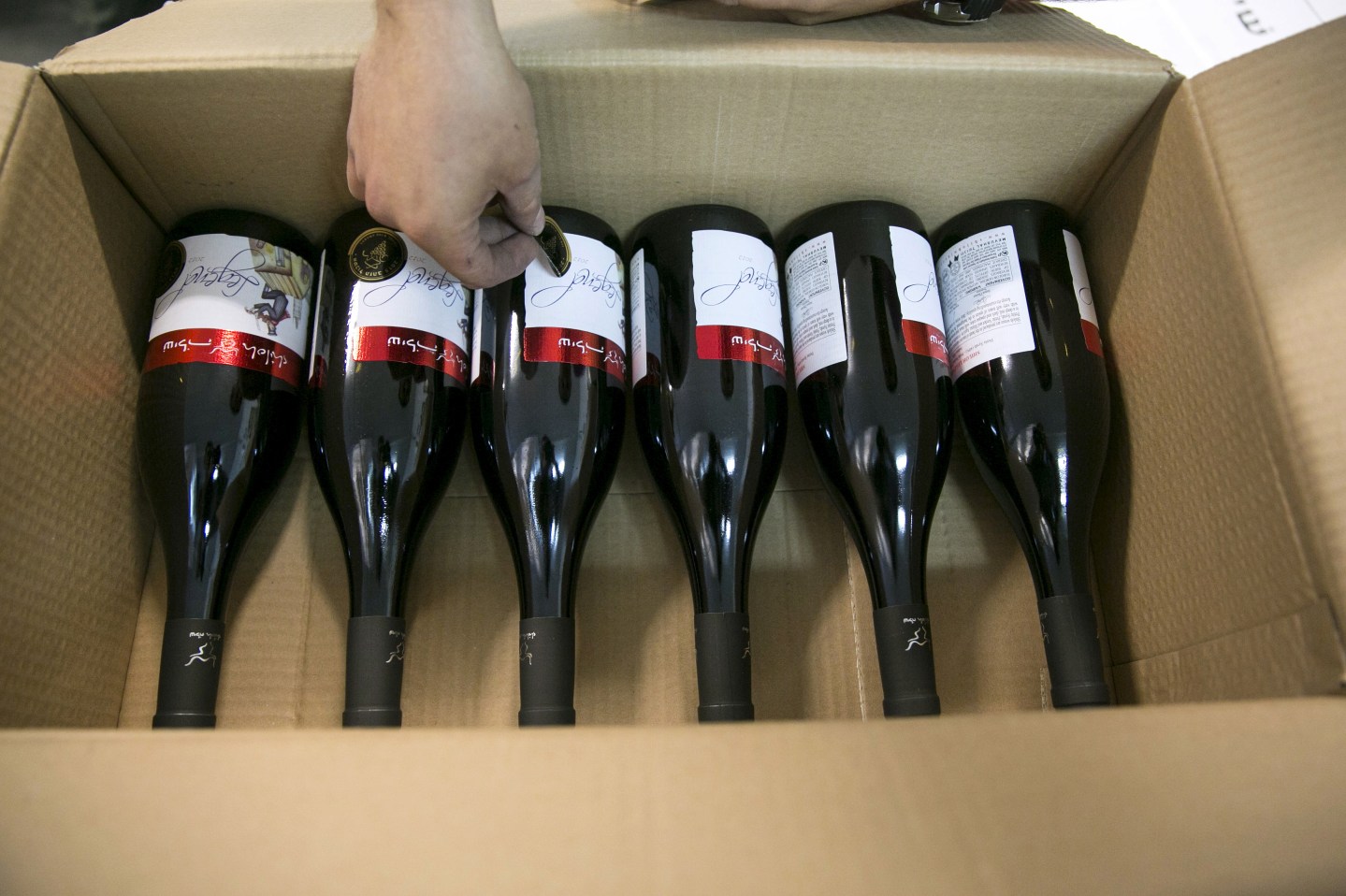 A worker places stickers on wine bottles, north of Ramallah