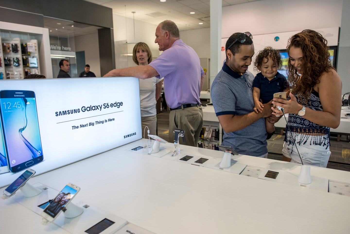 Customers look at a Samsung Corp. Galaxy S6 edge smartphone at a Sprint Corp. store in Palo Alto, California, U.S., on Friday, May 1, 2015. Sprint Corp. is scheduled to release earnings figures on May 5. Photographer: David Paul Morris/Bloomberg