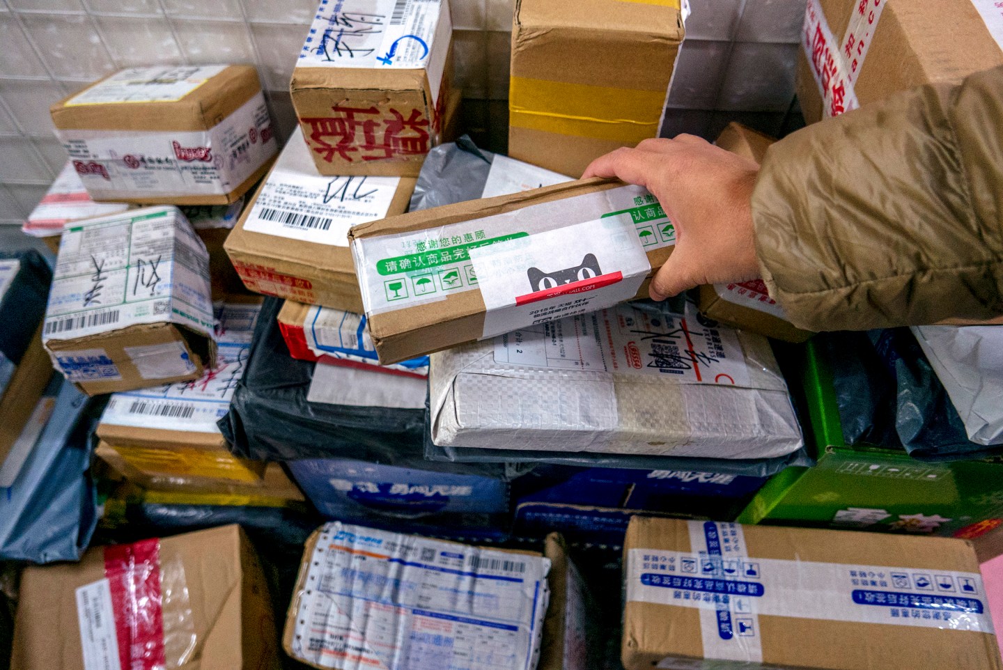 Packages are piled up in a small shop's Cainiao service