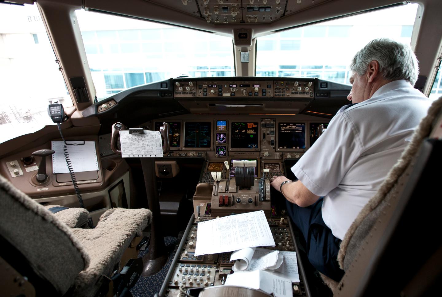 Pilot in the cockpit of a Boeing 777 at Denver International Airport.