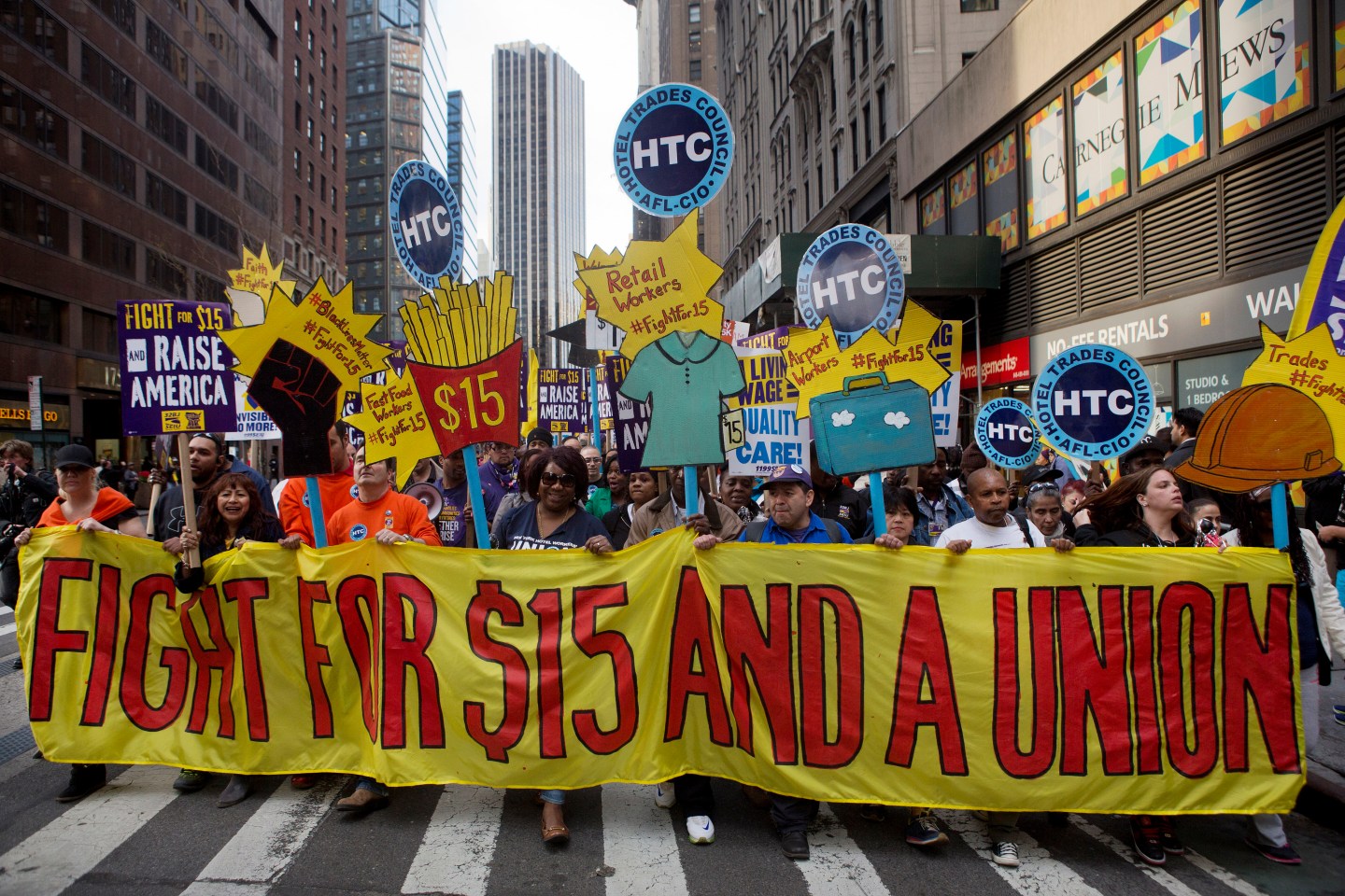 Protesters hold signs at a rally in support of minimum wage increase in New York, U.S., on Wednesday, April 15, 2015. Fast-food workers held rallies in 236 U.S. cities Wednesday in their biggest protest yet for higher pay and union rights. Photographer: Victor J. Blue/Bloomberg