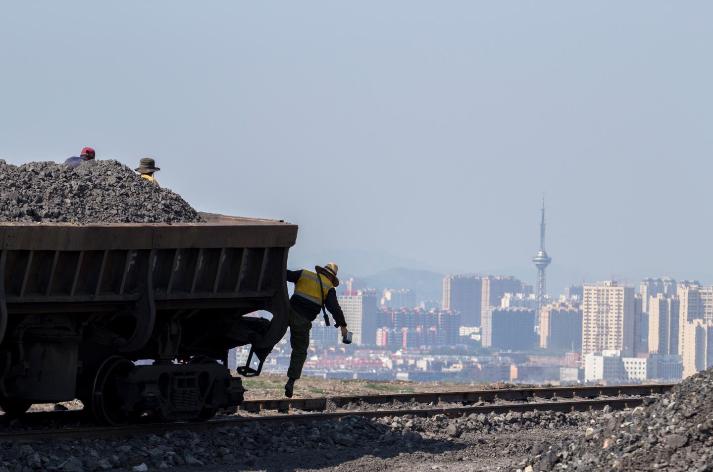 A worker is jumping down from the steam locomotive