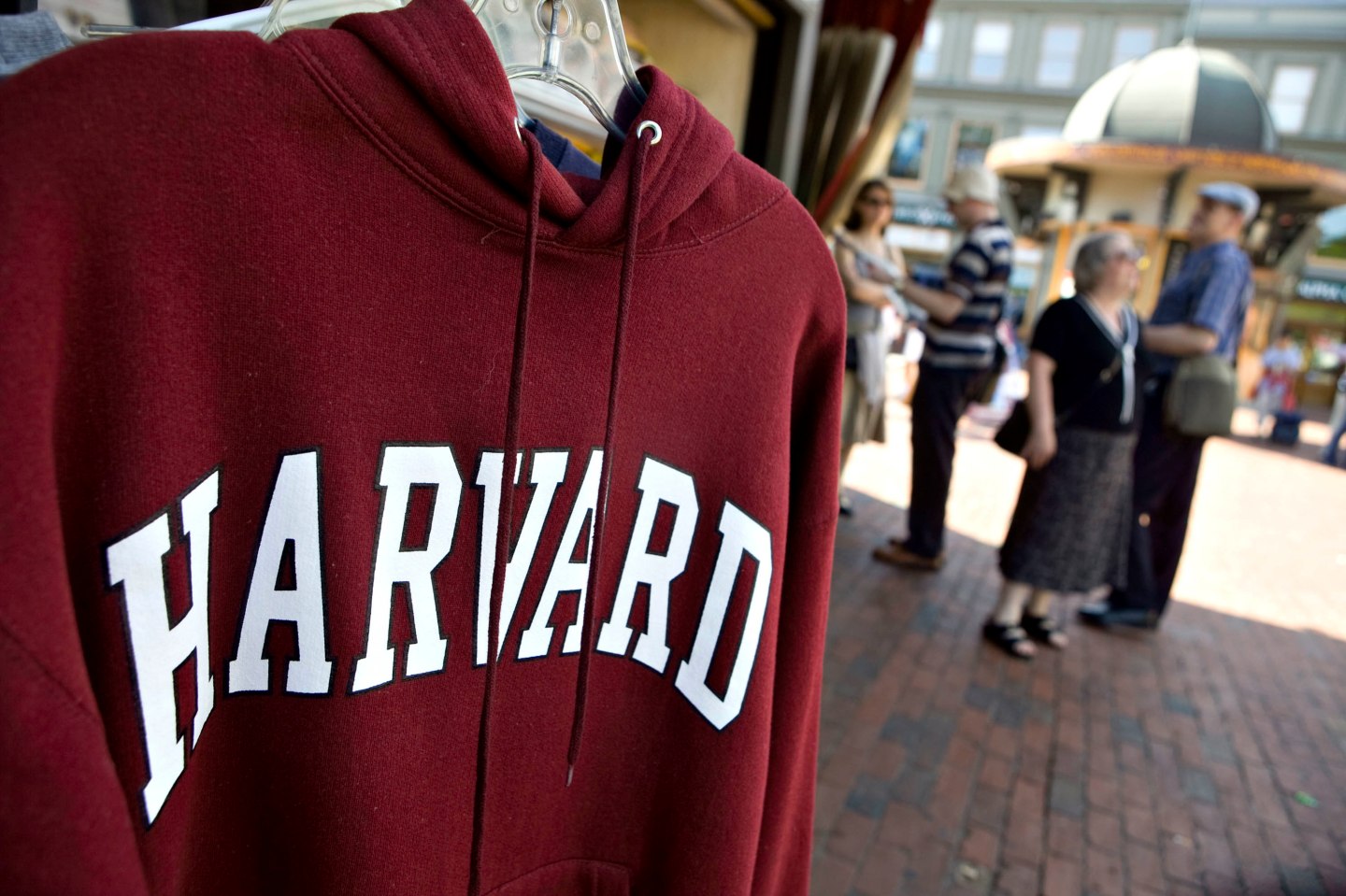 A Harvard University logo appears on a sweatshirt on display