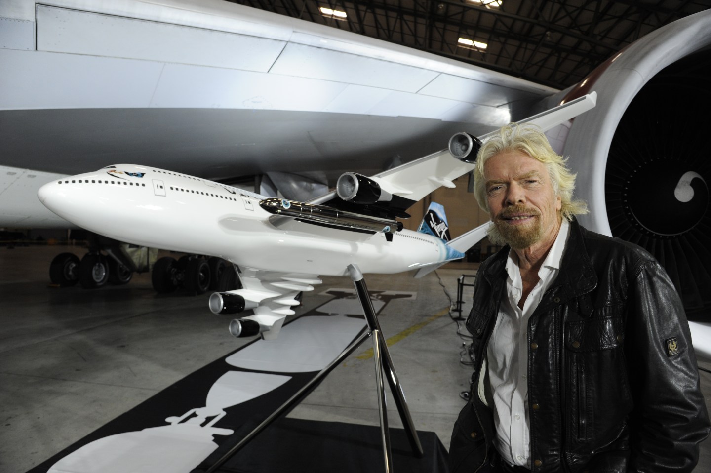 Virgin Galactic founder Richard Branson in front of a model of the repurposed Boeing 747 that will be used to launch the LauncherOne rocket.