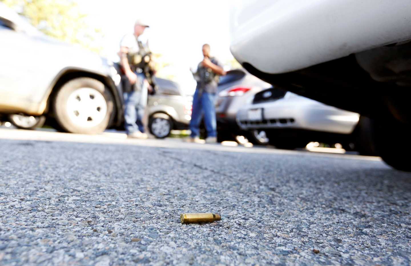 A spent cartridge lies on the ground as police officers secure the area after at least one person opened fire at a social services agency in San Bernardino