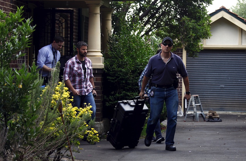 Australian Federal Police officers walk down the driveway after searching the home of probable creator of cryptocurrency bitcoin Craig Steven Wright in Sydney's north shore