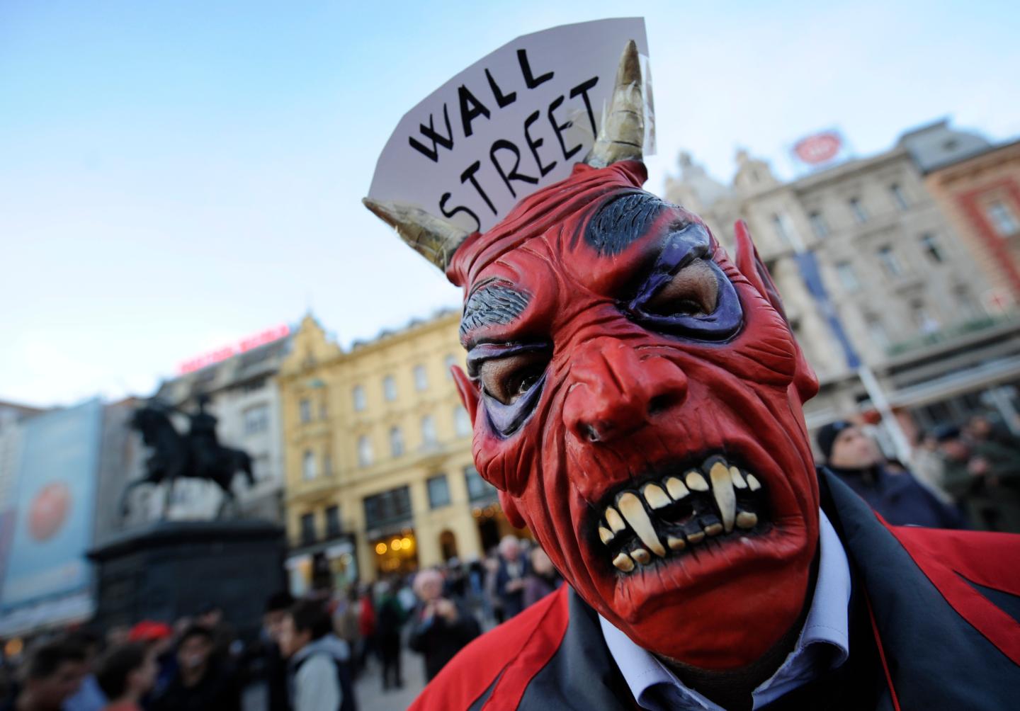 A protester wears a vampire mask with "W
