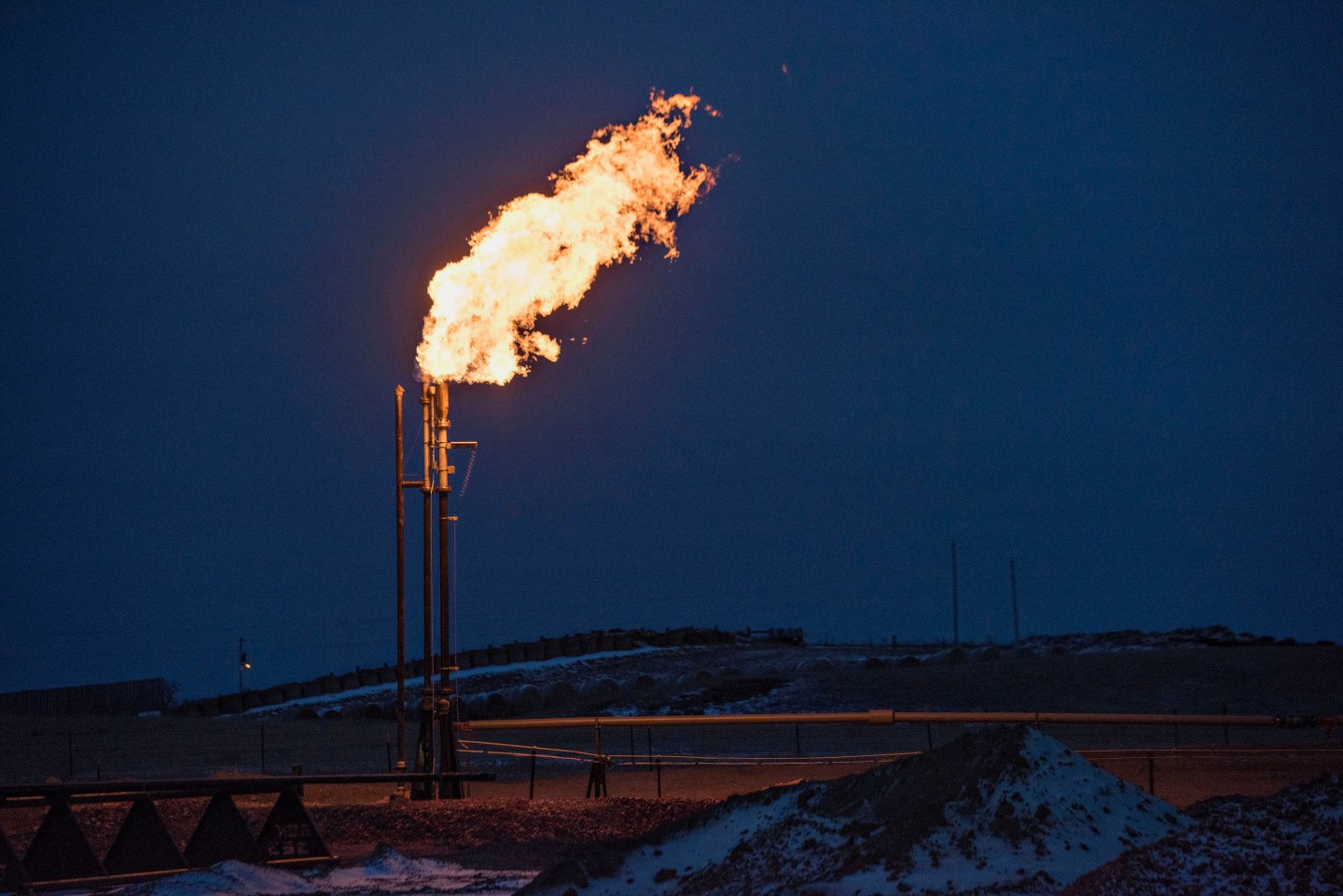 A gas flare burns at an oil well site near Sidney, Montana, U.S., on Saturday, Feb. 14, 2015. Photographer: Daniel Acker/Bloomberg