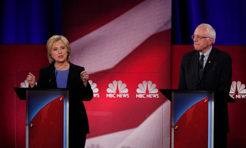 Democratic U.S. presidential candidate and former Secretary of State Hillary Clinton speaks as rival U.S. Senator Bernie Sanders listens at the NBC News - YouTube Democratic presidential candidates debate in Charleston