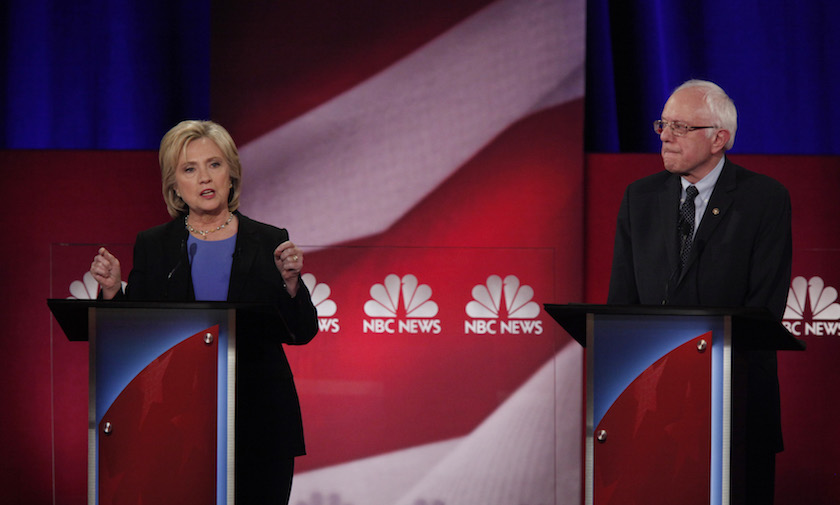 Democratic U.S. presidential candidate and former Secretary of State Hillary Clinton speaks as rival U.S. Senator Bernie Sanders listens at the NBC News - YouTube Democratic presidential candidates debate in Charleston