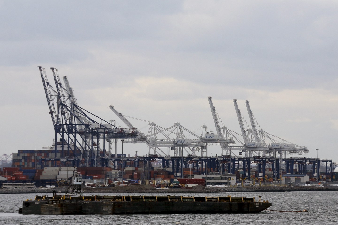 A barge is seen as containers are stacked at the Port in Bayonne, New Jersey during a work stoppage in the harbor of New York