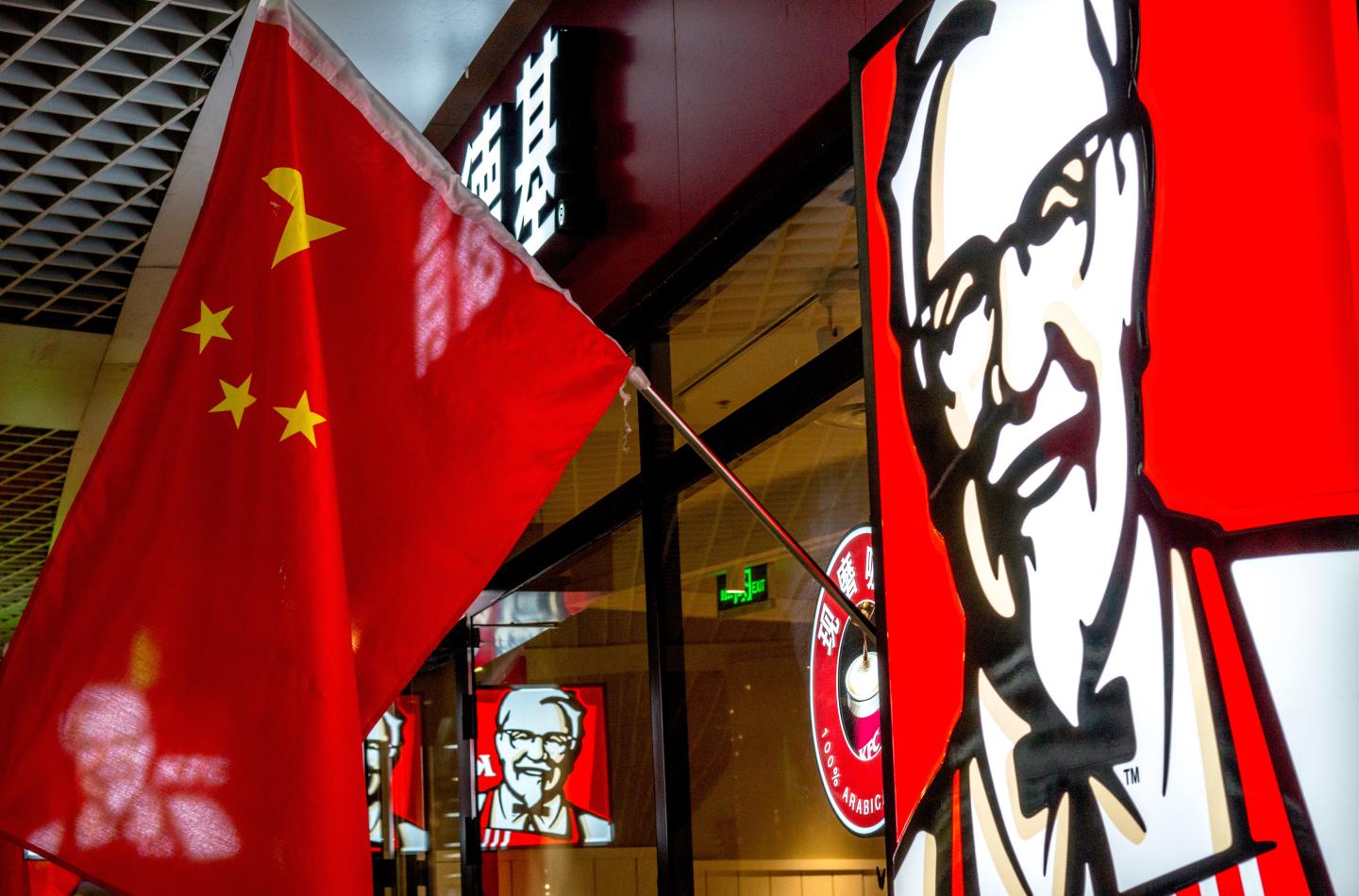 TIANJIN, CHINA - 2015/02/21: A KFC restaurant hangs up China's national flags in lunar new year.  KFC restaurants in China will start selling freshly ground coffee in 2015 to become a lower-cost “premium” alternative to Starbucks. The initiative began earlier this year and is expected to perform in 2,500 KFCs in China by the end of this year. (Photo by Zhang Peng/LightRocket via Getty Images)
