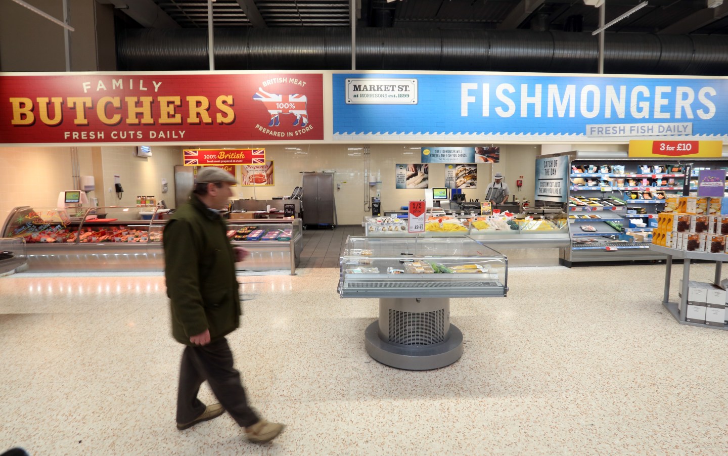 A customer passes the butcher and fishmonger counters at a Morrisons supermarket, operated by William Morrisons Supermarkets Plc, in Crawley, U.K., on Tuesday, March 25, 2015. Wm Morrison Supermarkets Plc named David Potts as chief executive officer, tasking the former head of Tesco Plc's Asia unit with reviving the ailing British grocer. Photographer: Chris Ratcliffe/Bloomberg