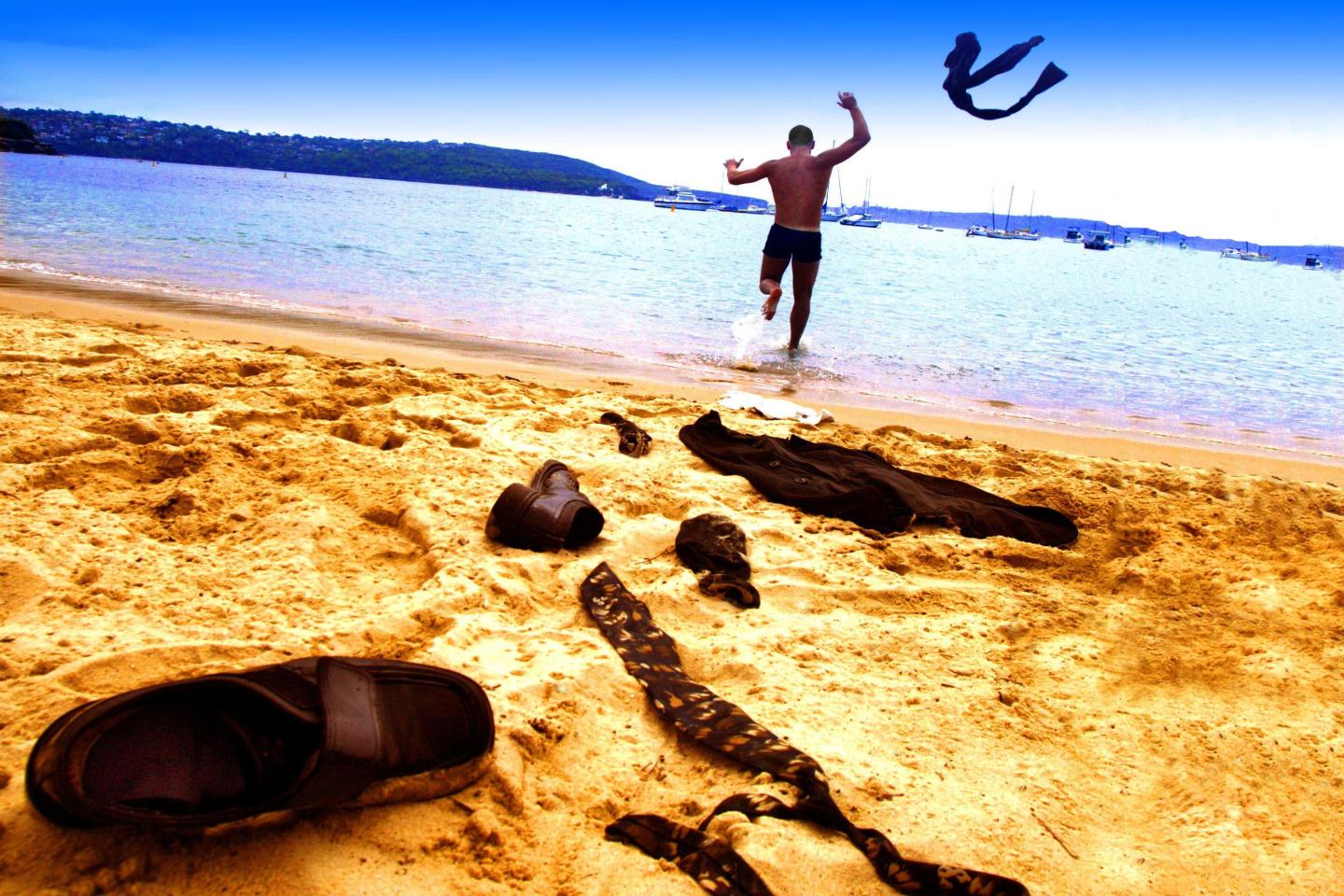 Businessman on the beach takes off his clothes and runs into the water, 11 Novem