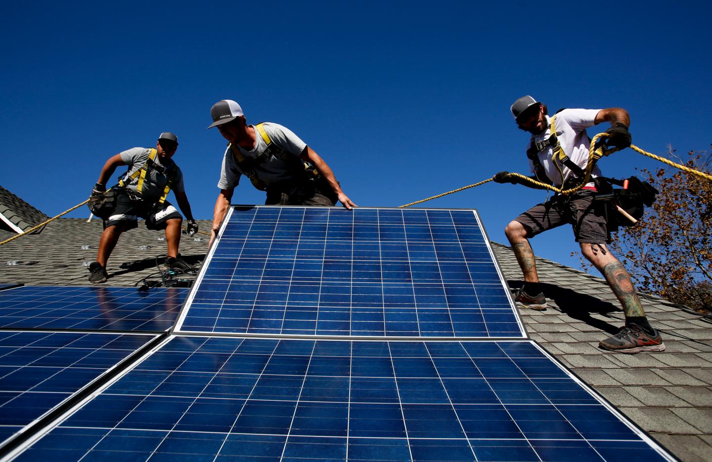 Rogelio Mora (CQ), left, Tyler Smith, center, and Randy Murray, right, workers from vivint.solar in