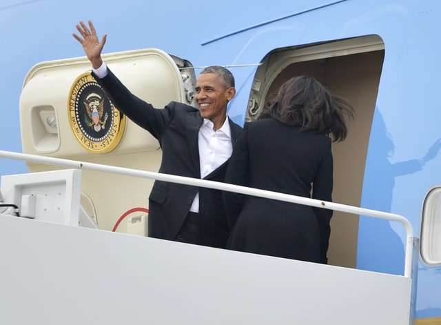 U.S. President Barack Obama waves as first lady Michelle Obama enters the door of Air Force One at Joint Base Andrews, Maryland, for their historic visit to Cuba