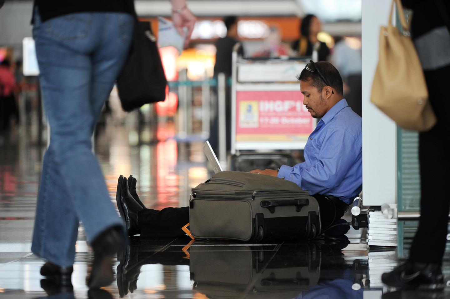 A man uses his laptop while waiting at H