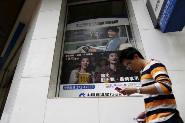 A man walks past an advertisement for young customers of China Construction Bank, in Hong Kong, China