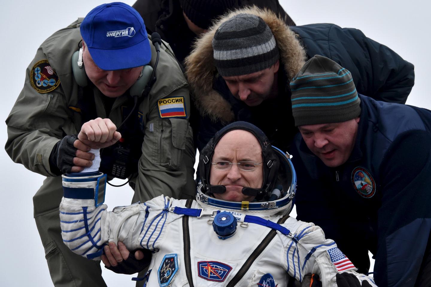 Ground personnel help U.S. astronaut Scott Kelly to get out of a Soyuz capsule shortly after landing near the town of Dzhezkazgan