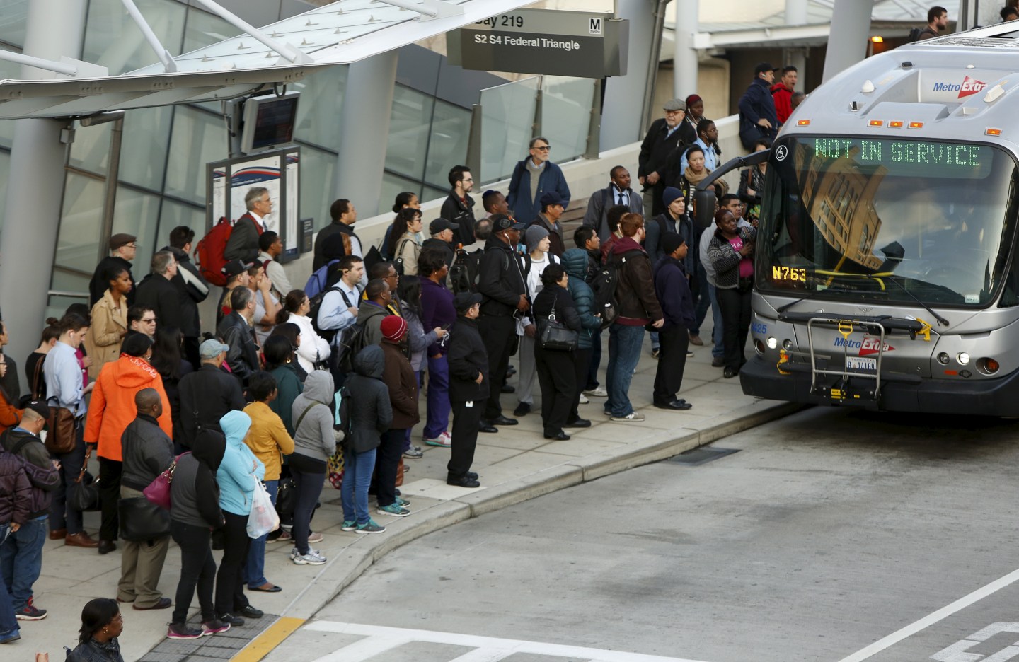 Morning commuters board bus for downtown Washington in Silver Spring, Maryland